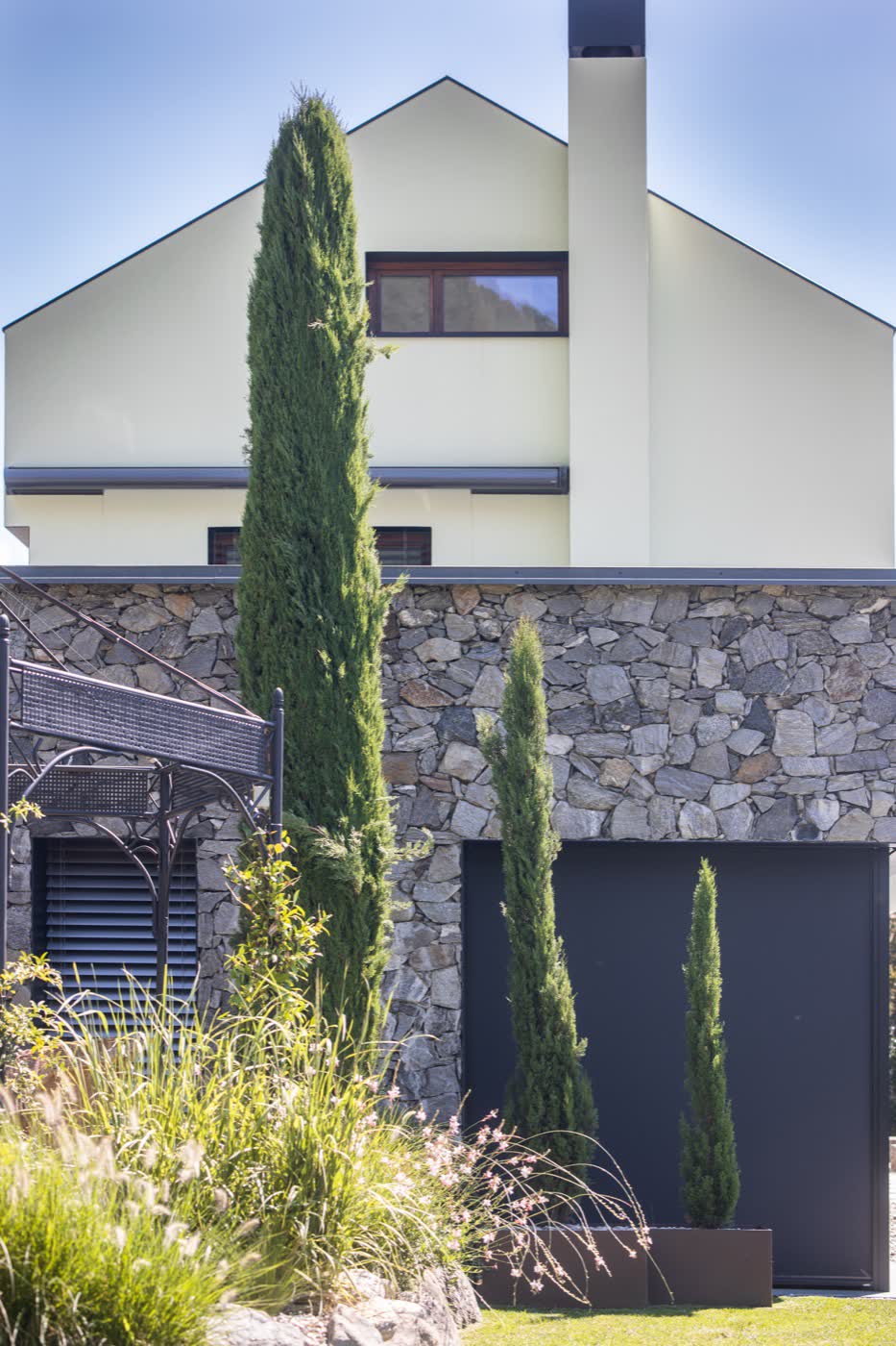 La casa vista dal giardino, con i cipressi