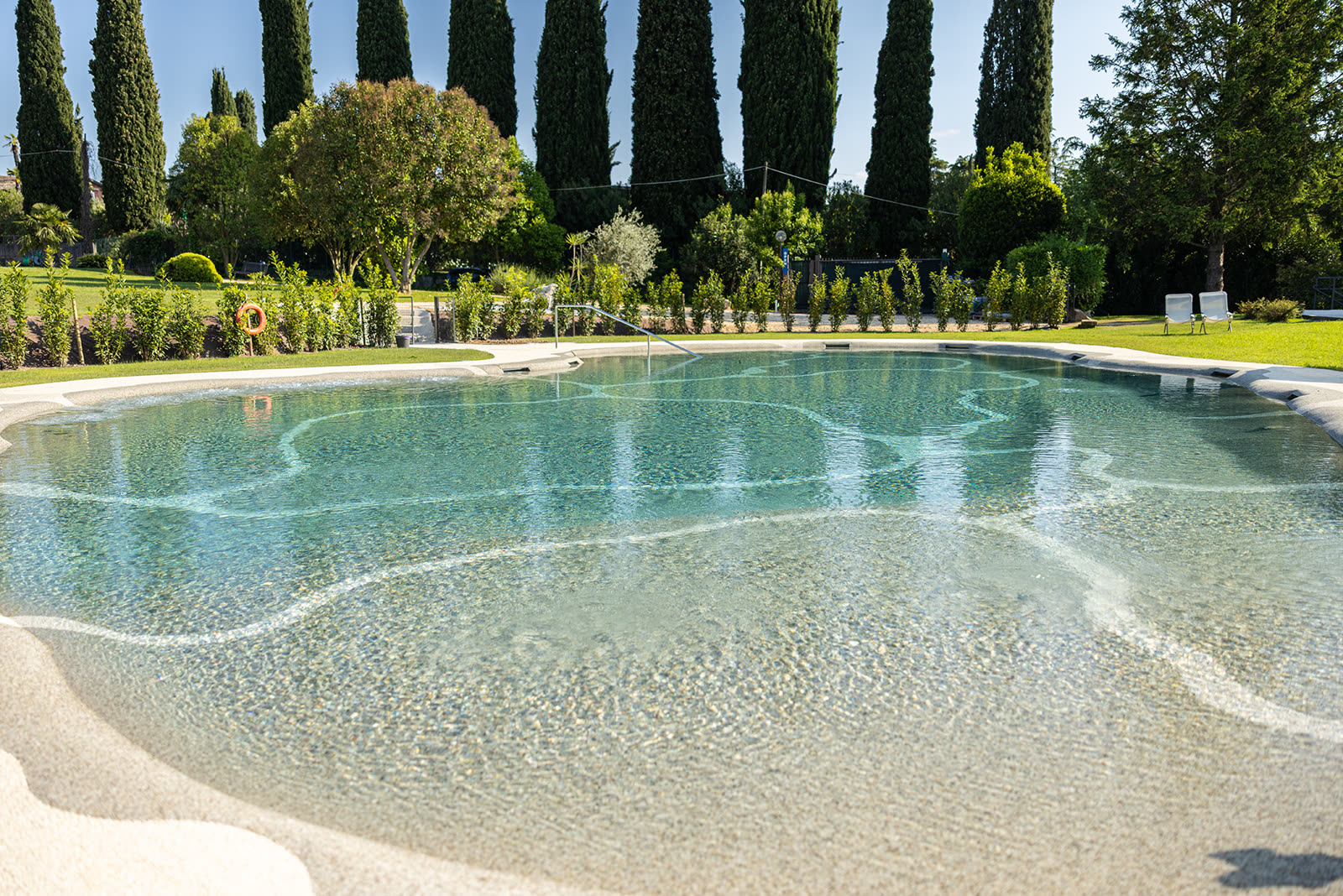 Piscina biodesign tra i cipressi