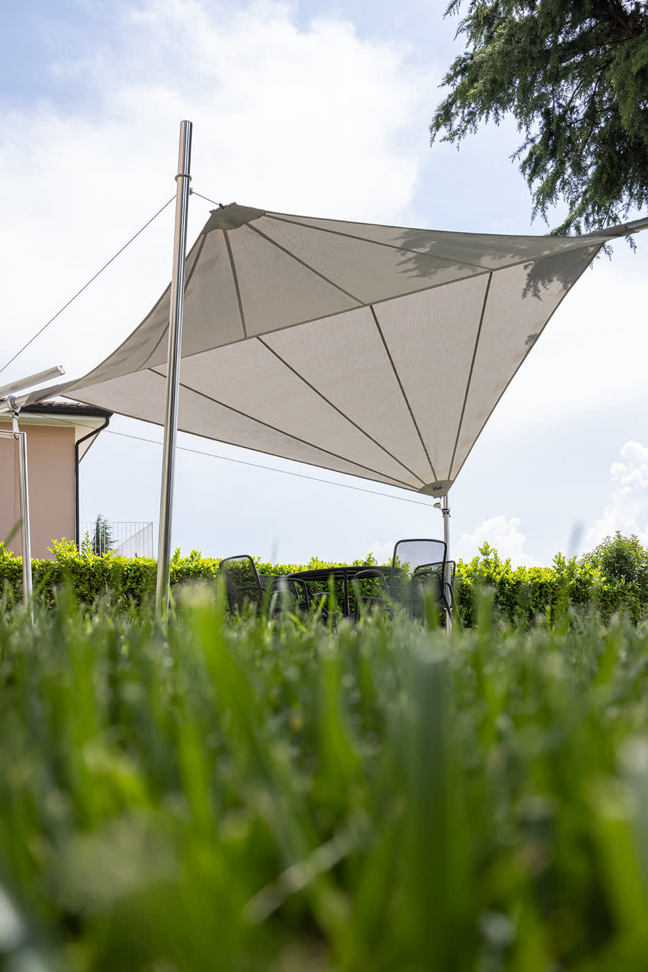Vela ombreggiante sul prato fra i cipressi