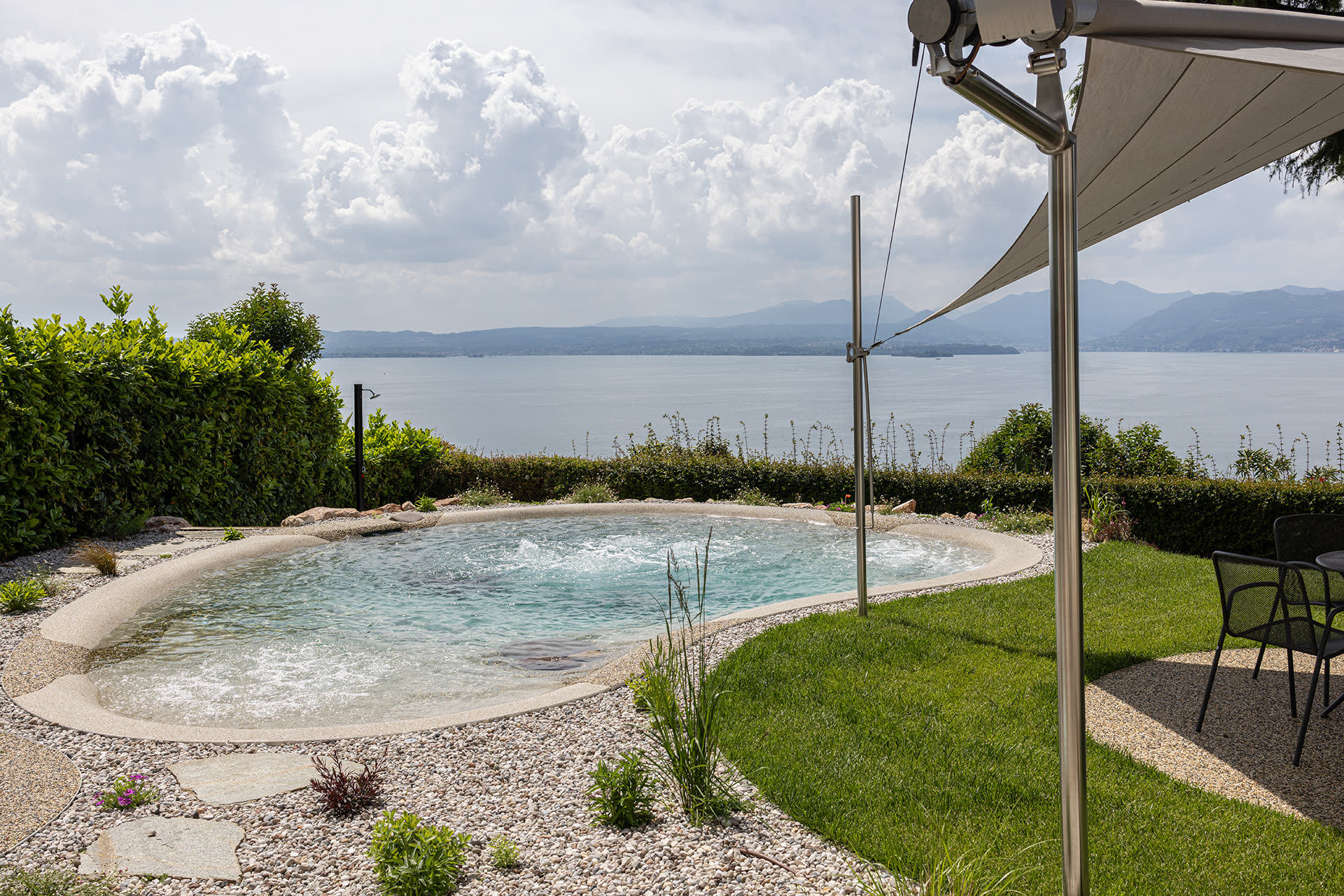 Vela ombreggiante sopra una piscina con vista sul lago